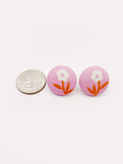 Handmade pink fabric-covered earrings with orange-stemmed flowers. The earrings are shown next to a quarter for size reference.