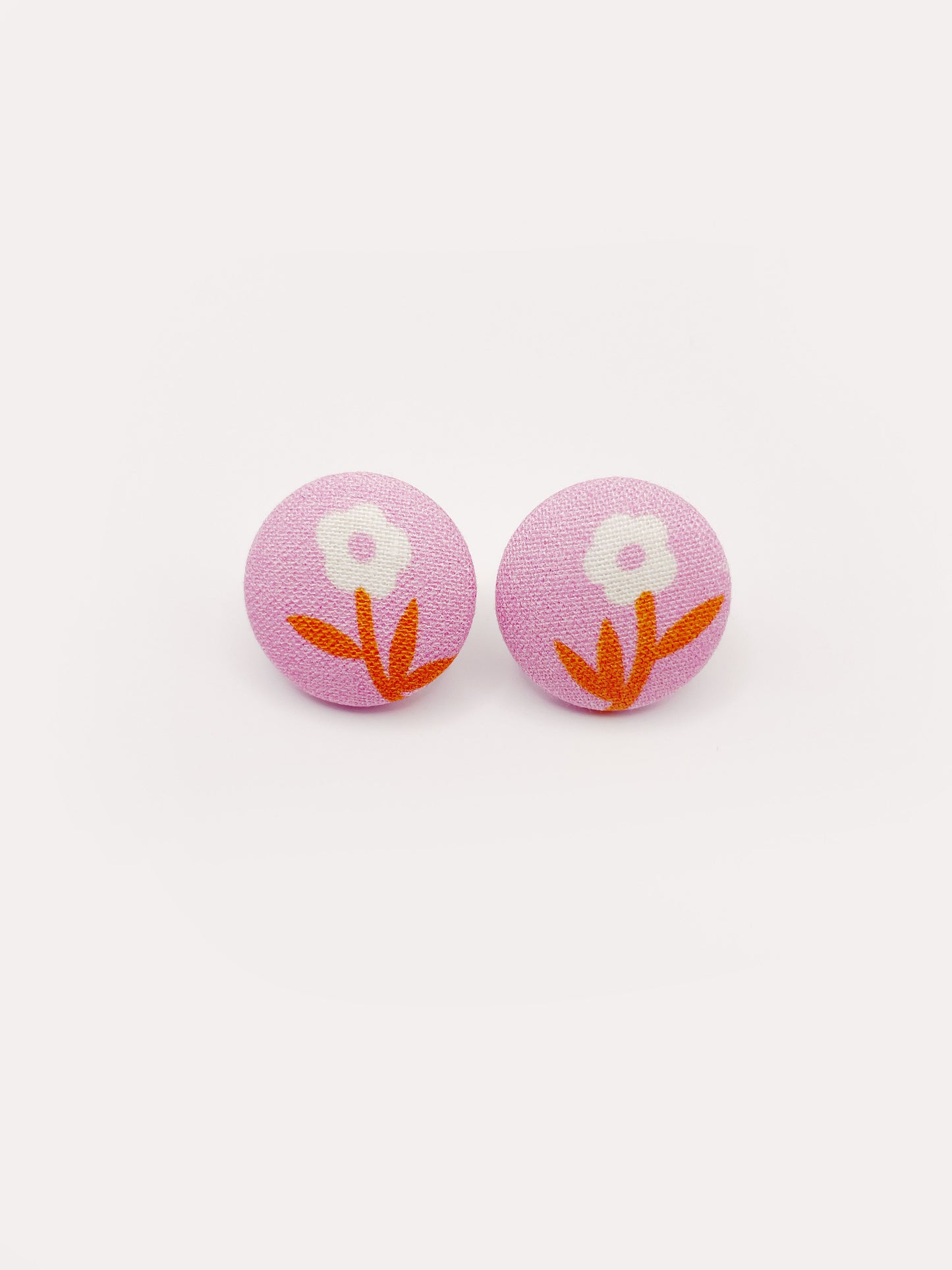 Handmade pink fabric-covered earrings with orange-stemmed flowers. 