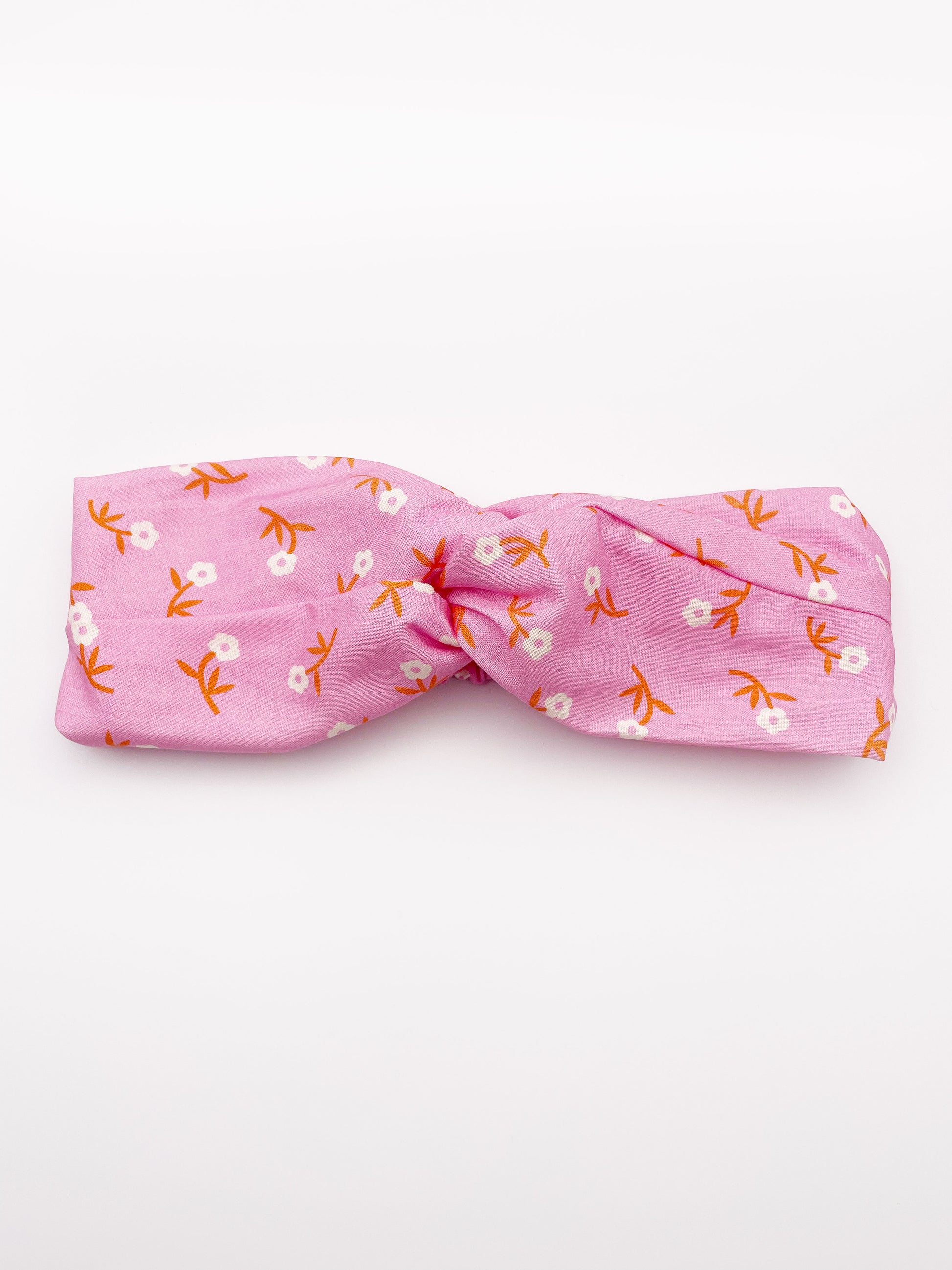 A cheerful pink twist headband with orange-stemmed flowers.