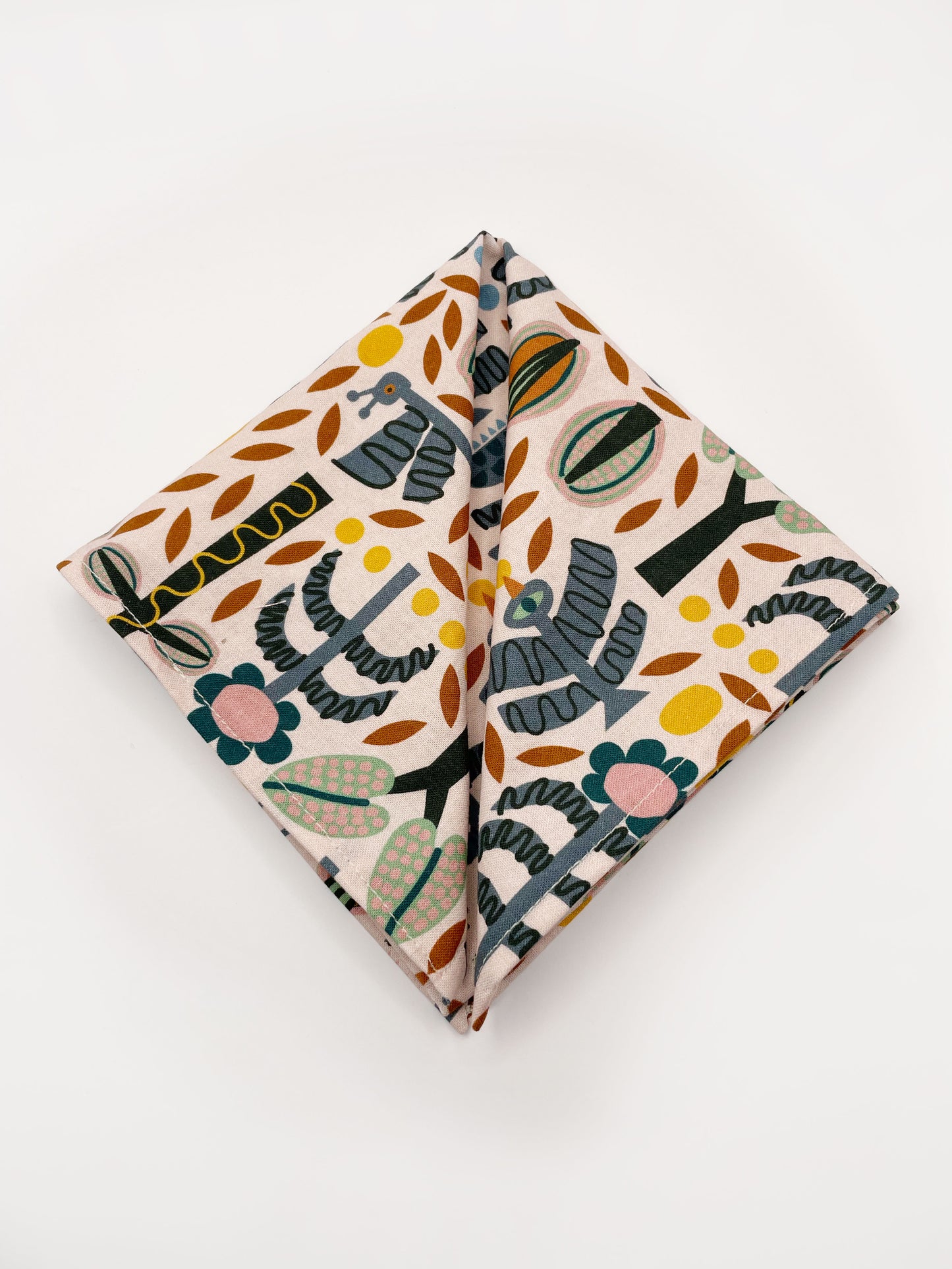 A pocket square featuring a bold nature-inspired print of bugs, plants, suns, and rainbows.