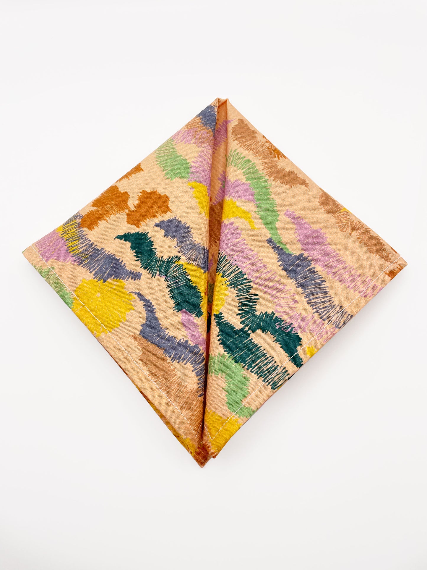 A pocket square crafted from high-quality cotton with an abstract design inspired by the rolling hills and earthy tones of the desert.