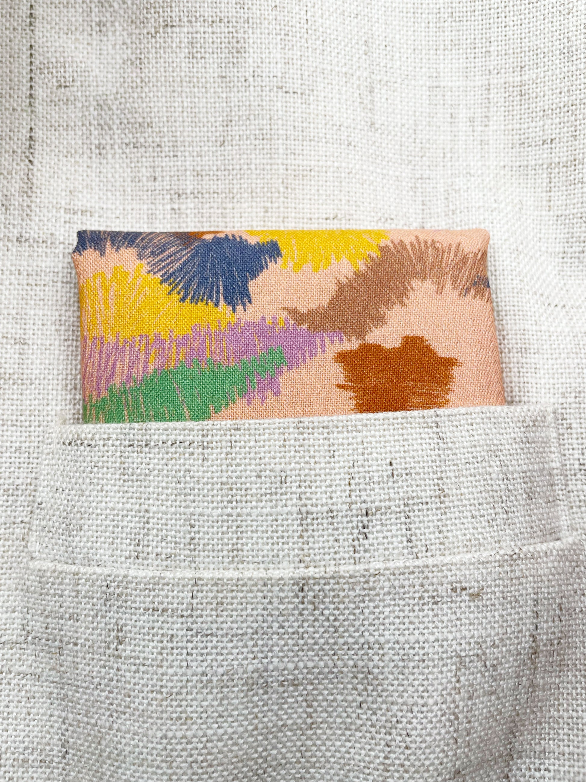 A pocket square crafted from high-quality cotton with an abstract design inspired by the rolling hills and earthy tones of the desert.