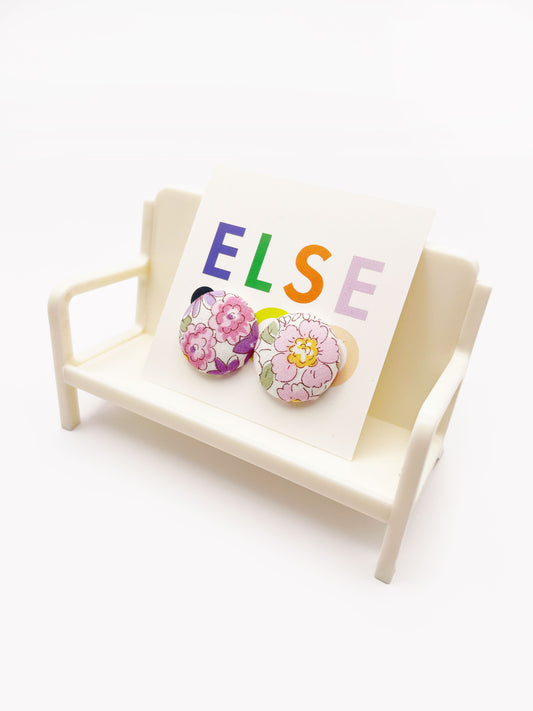 Handmade purple floral fabric covered post earrings. The earrings are on a backing card that says "Else Co". The earrings are shown on a small white plastic chair.