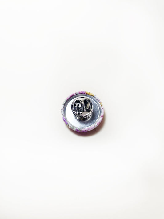 Handmade purple floral fabric covered lapel pin. Each pin has a clutch back closure.