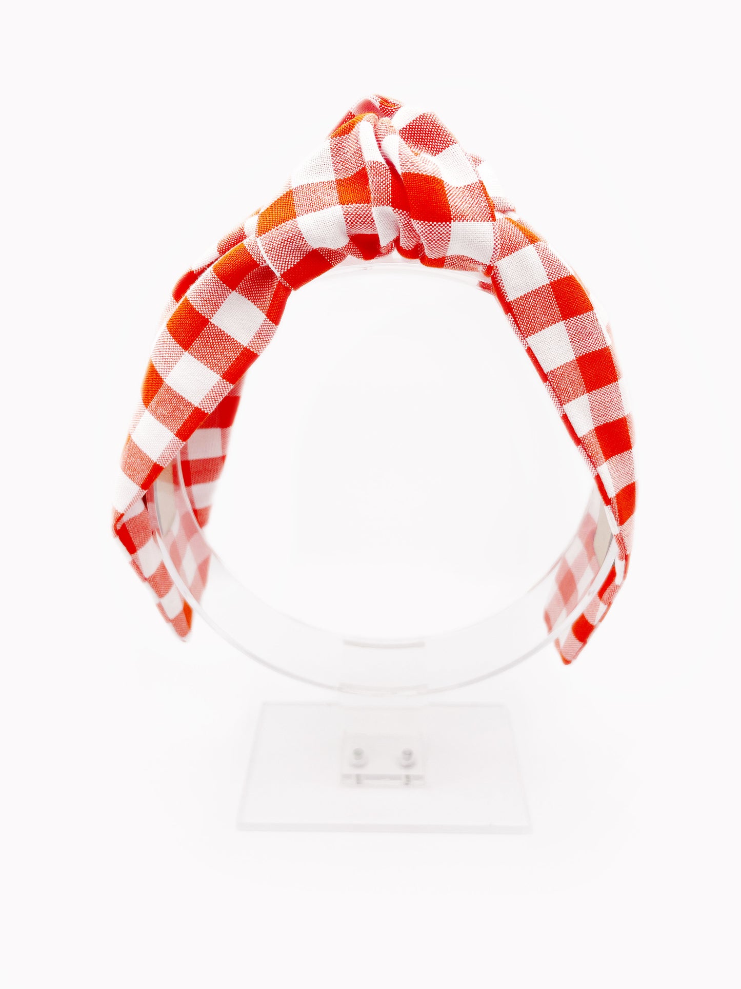 Cotton knotted headbands with a vibrant red gingham plaid print. The headband is displayed on an acrylic stand.