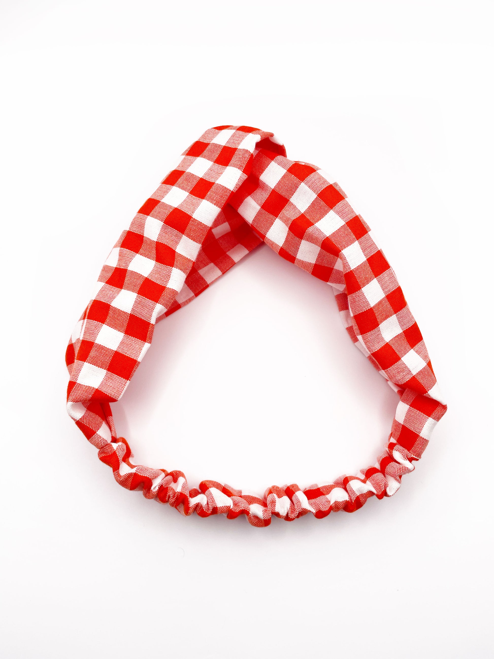 A cotton twist headband with a vibrant red gingham plaid print. 