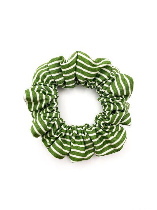 A handmade green scrunchie made with cotton fabric featuring white stripes.