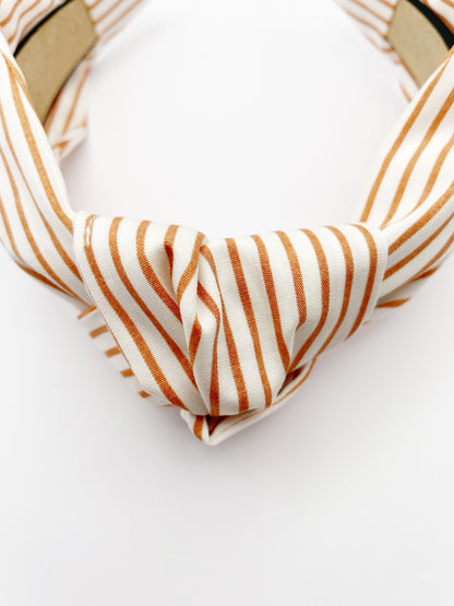 A handmade copper striped knotted headband.