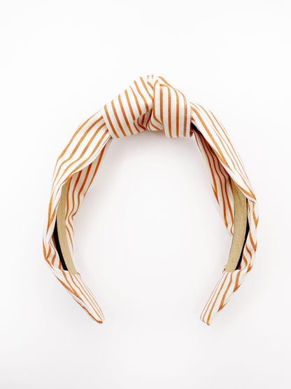 A handmade copper striped knotted headband.