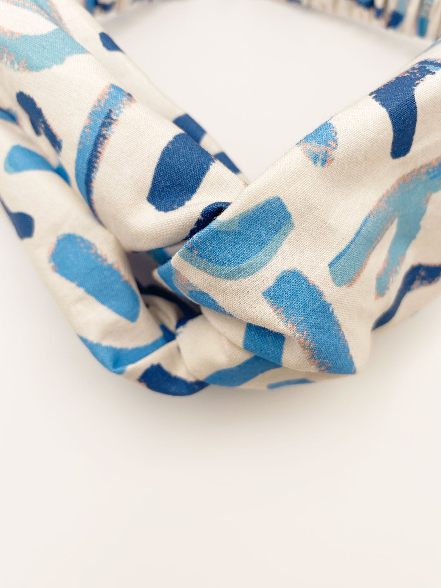 A twist headband featuring a bold blue cactus print. 