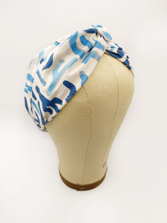 A twist headband featuring a bold blue cactus print. The headband is shown on a mannequin head.