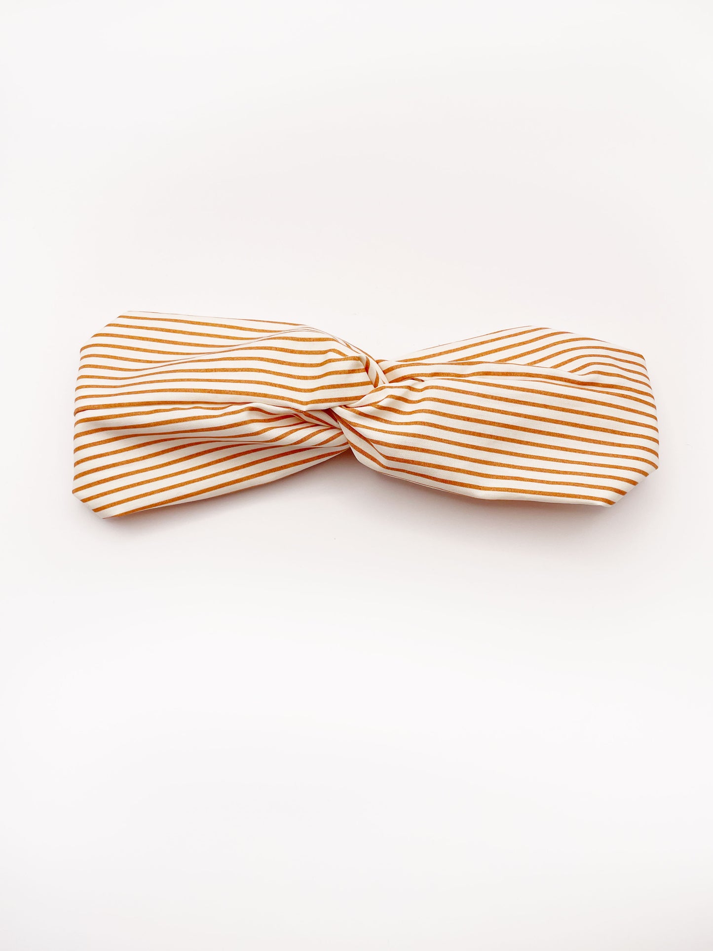 A handmade tan striped twist headband with an elastic band in the back.