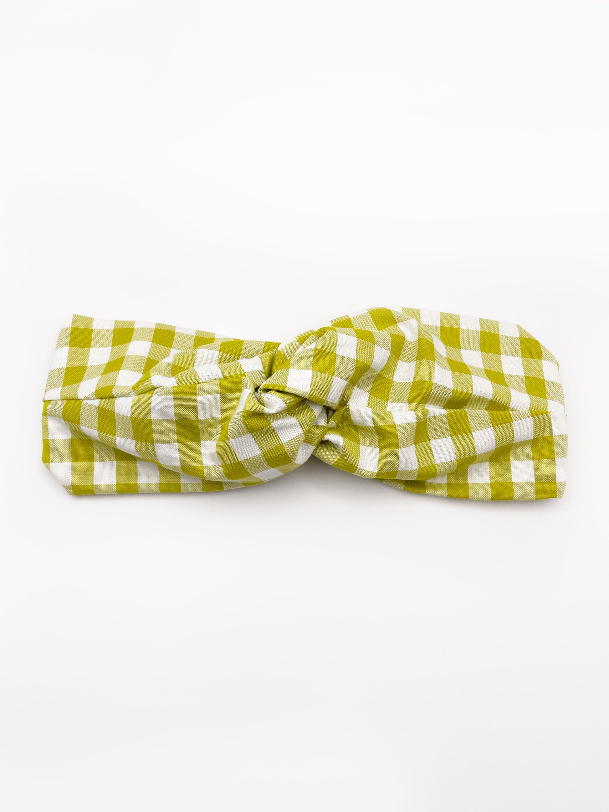 A handmade twist headband with a green and white gingham plaid print. The headband has an elastic band in the back. 