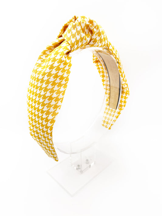 A handmade yellow houndstooth knotted headband.