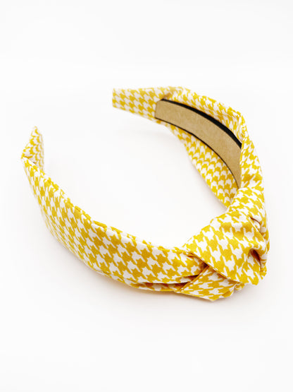 A handmade yellow houndstooth knotted headband.