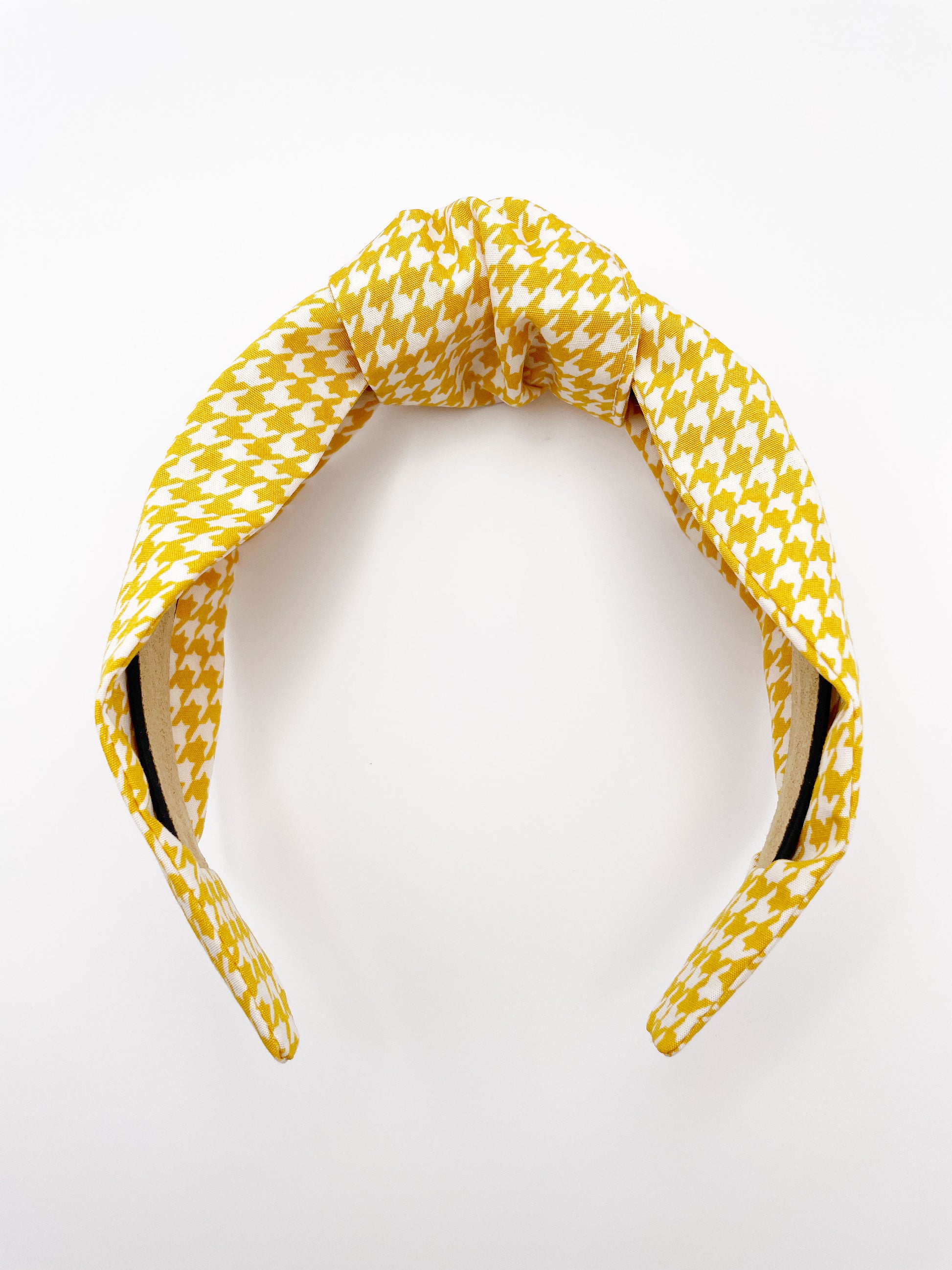 A handmade yellow houndstooth knotted headband.