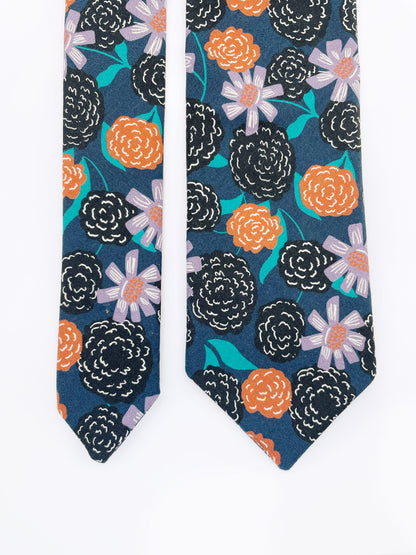 A navy blue necktie with vivid orange, lavender, and black flowers, accented with fresh green leaves.