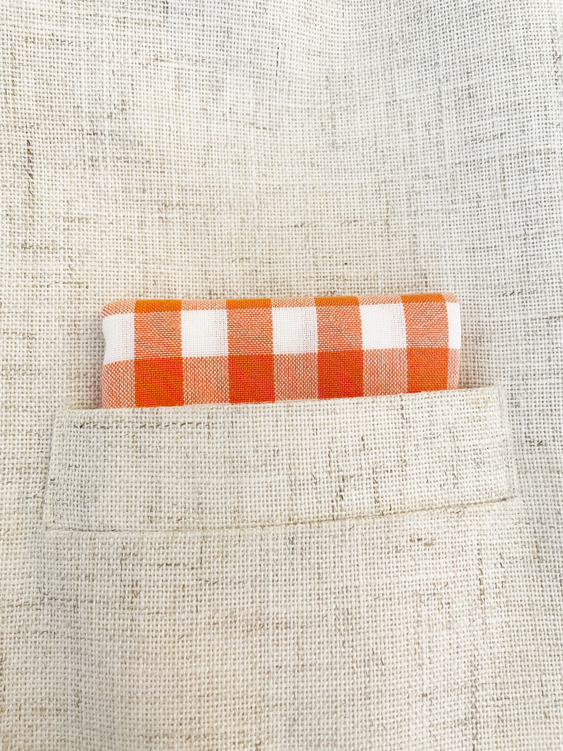 An orange and white gingham plaid pocket square.