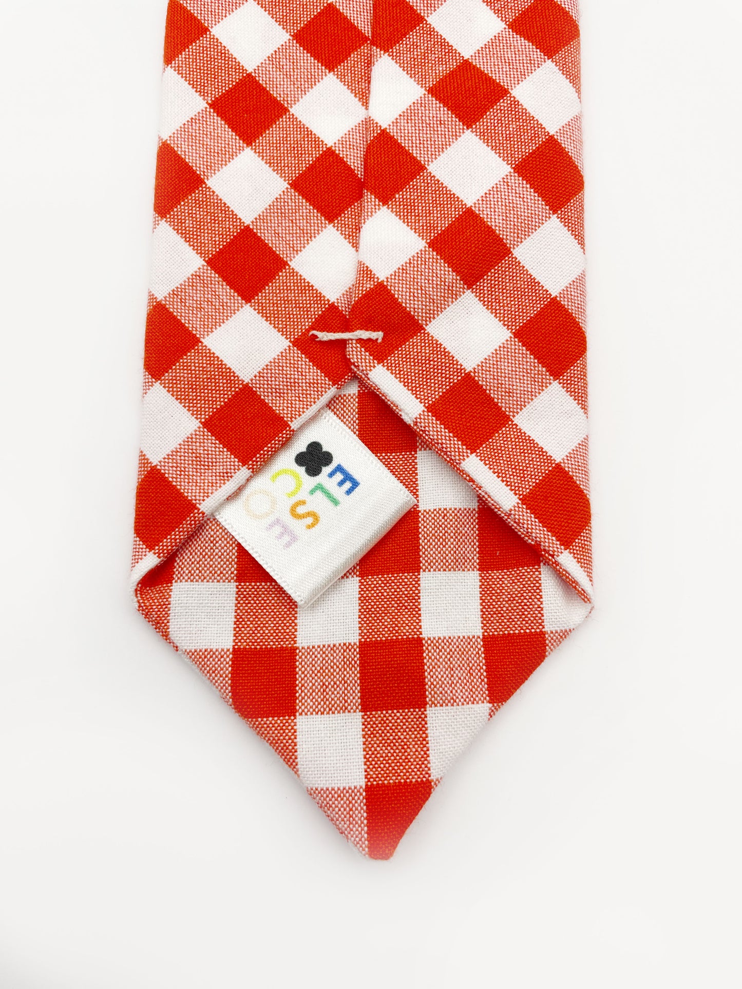 A cotton necktie with a vibrant red gingham plaid print. Each necktie is carefully hand-stitched.