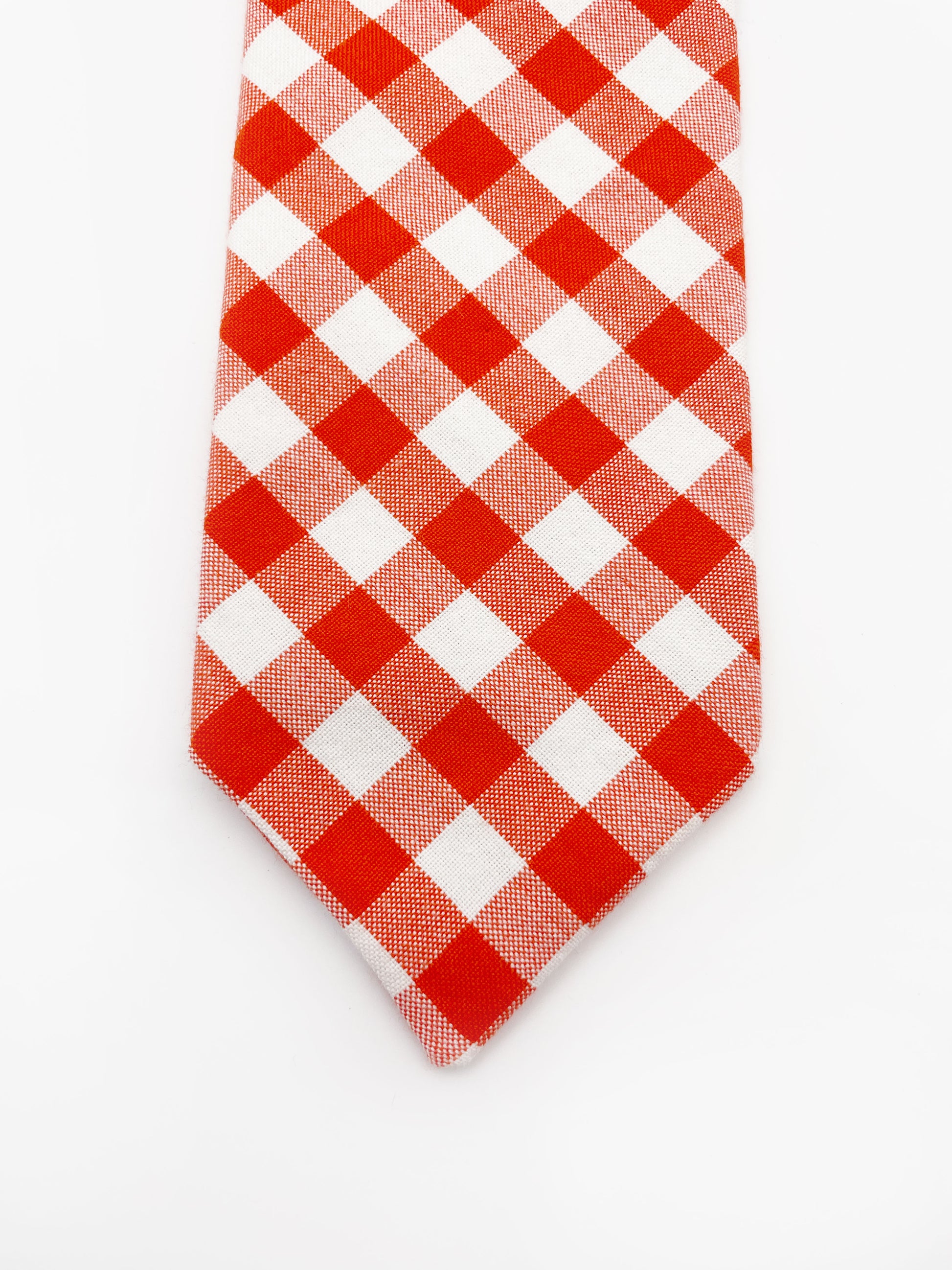 A cotton necktie with a vibrant red gingham plaid print.