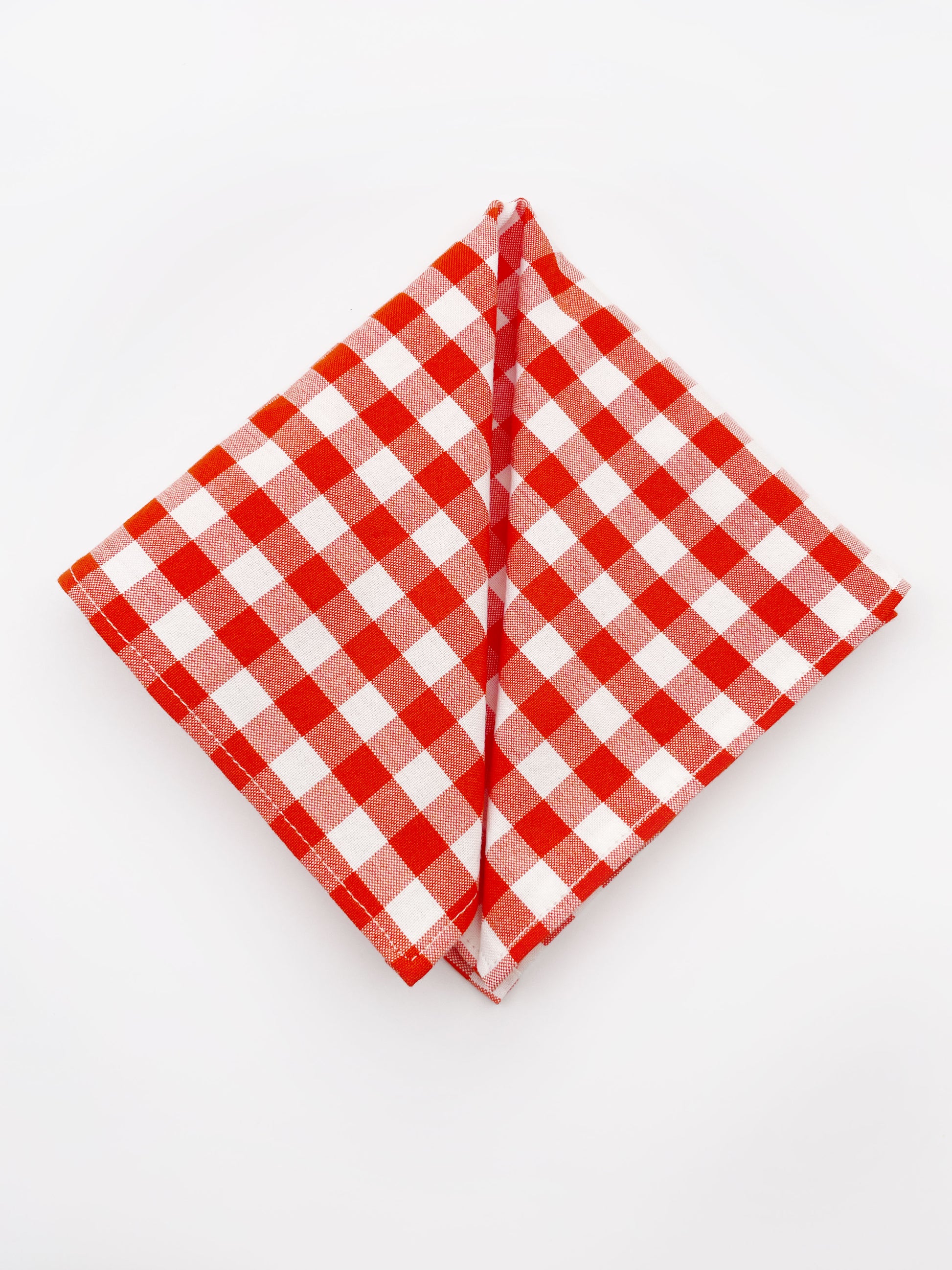 A cotton handmade pocket square with a red gingham plaid print. 