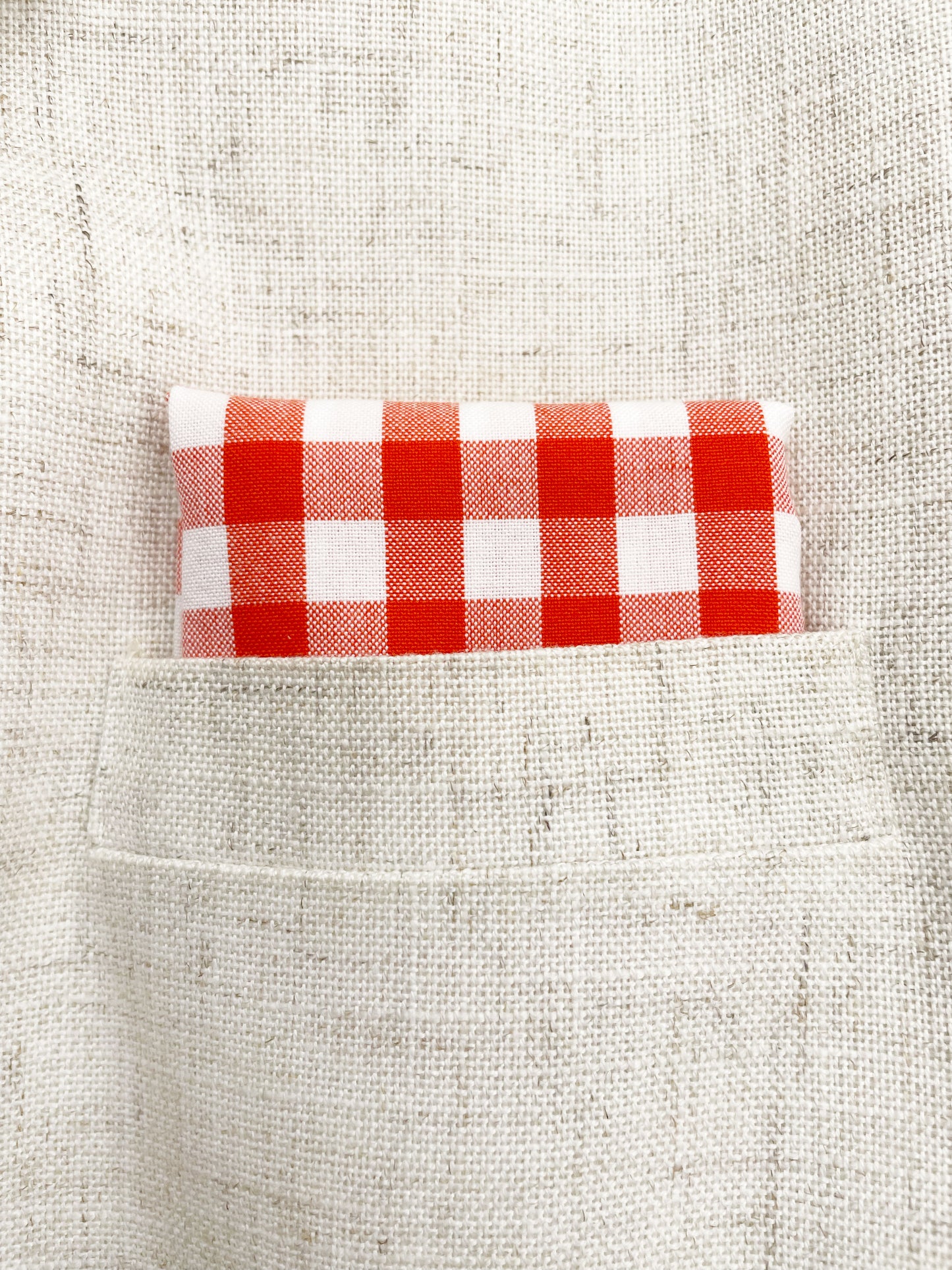 A cotton handmade pocket square with a red gingham plaid print. 