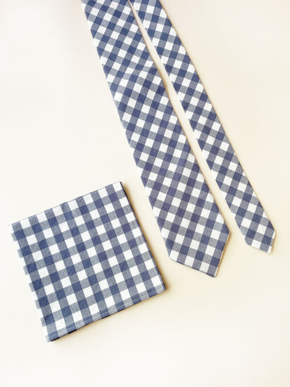 A handmade slate blue gingham plaid necktie with a matching pocket square.