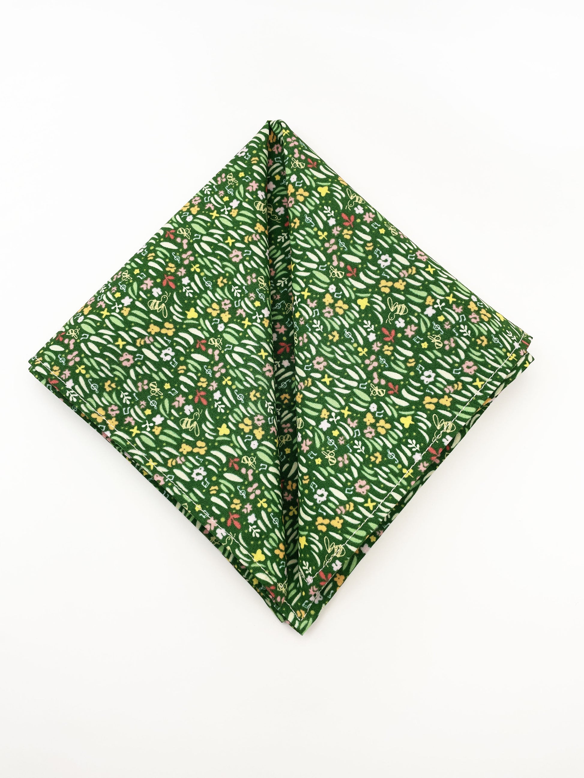 A handmade green floral pocket square with a grass print.