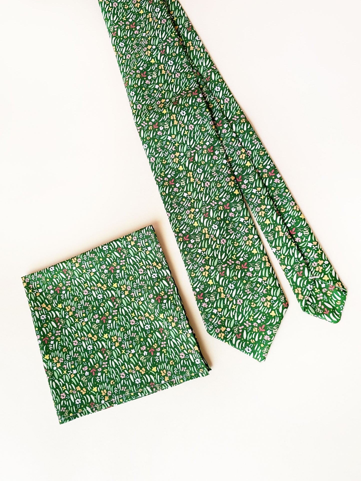 A handmade green floral pocket square with a grass print.