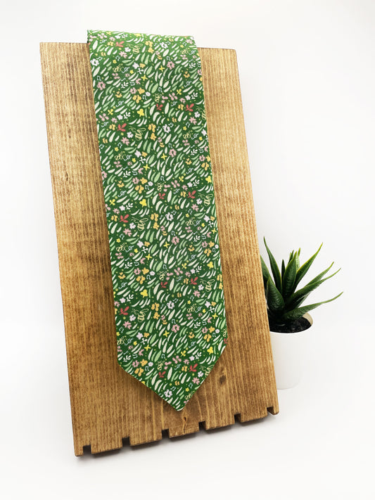 A handmade green floral necktie with grass print.