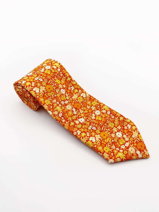 A handmade orange floral necktie with a small ditsy flower print. 