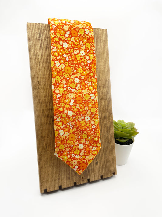 A handmade orange floral necktie with a small ditsy flower print. 