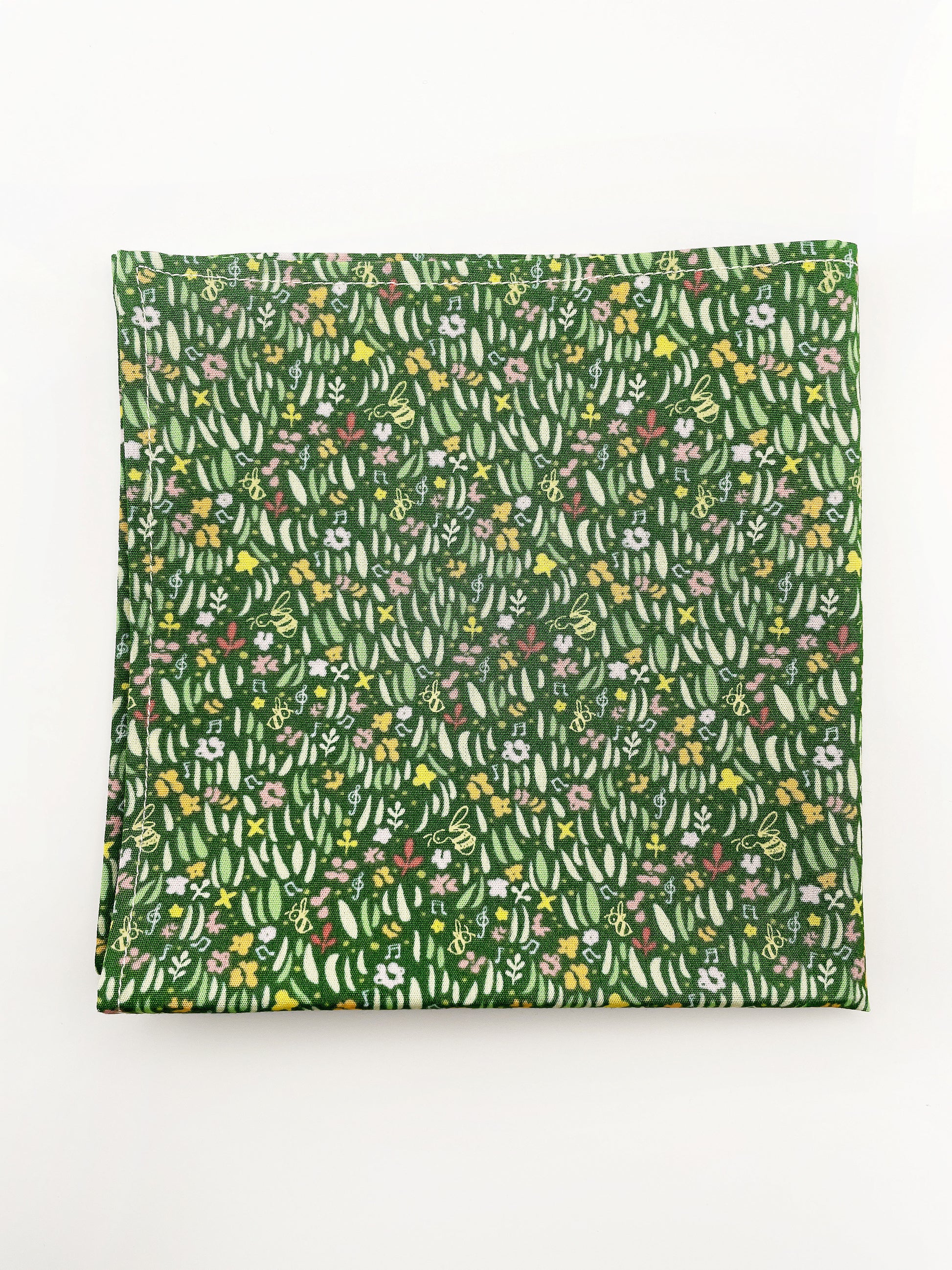 A handmade green floral pocket square with a grass print.