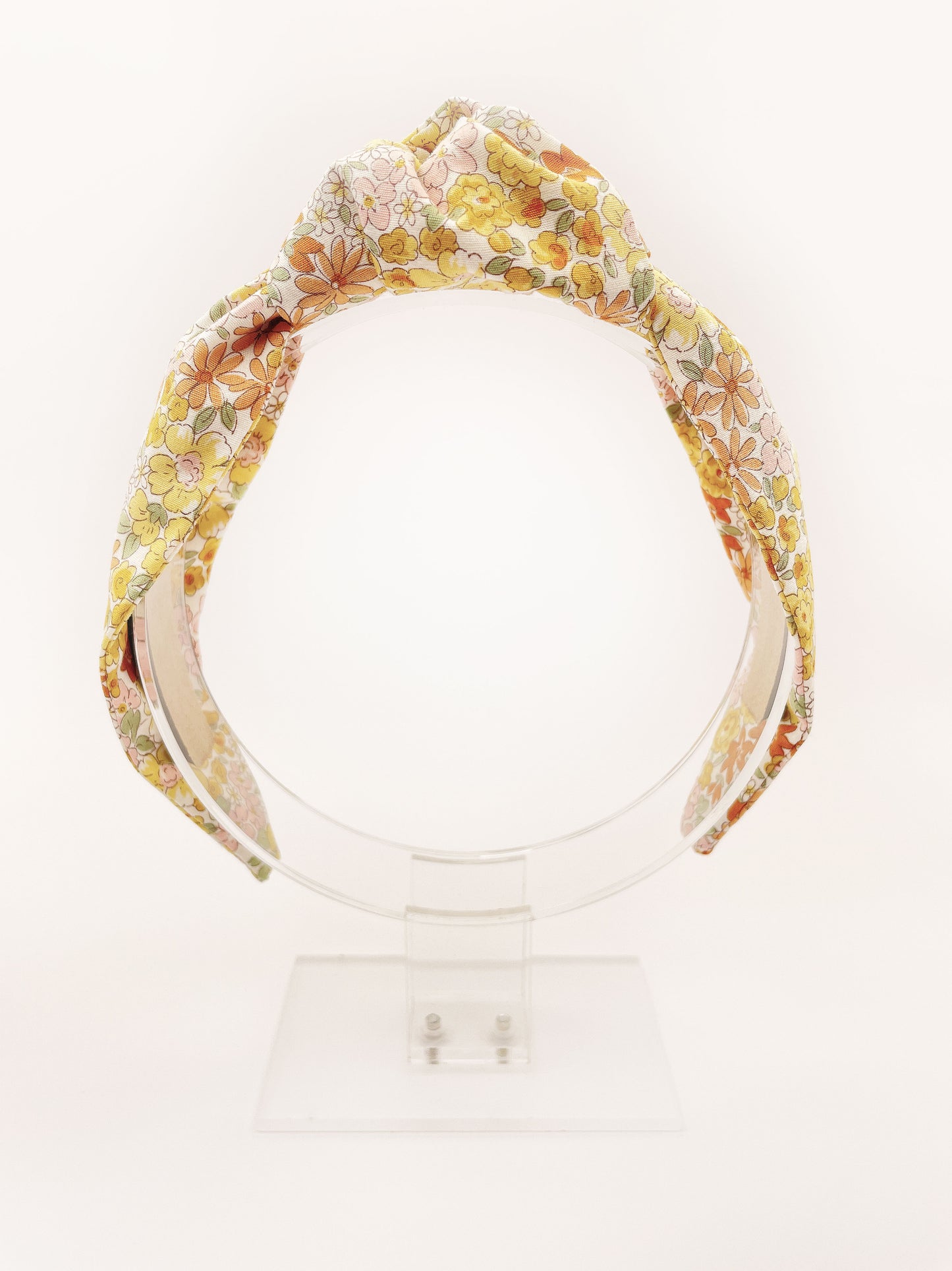 Handmade knotted headband with yellow flowers against an off white background