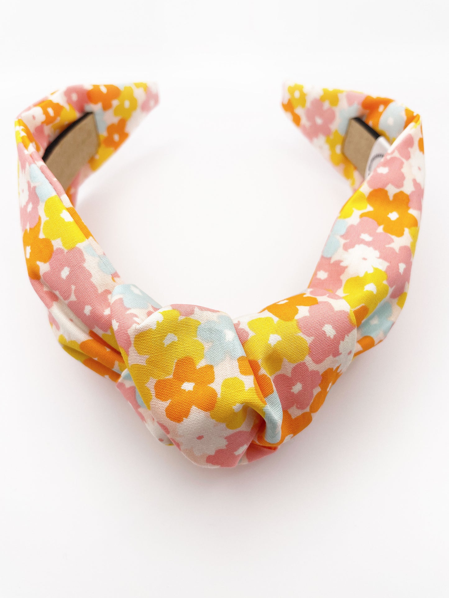 A handmade colorful floral knotted headband.