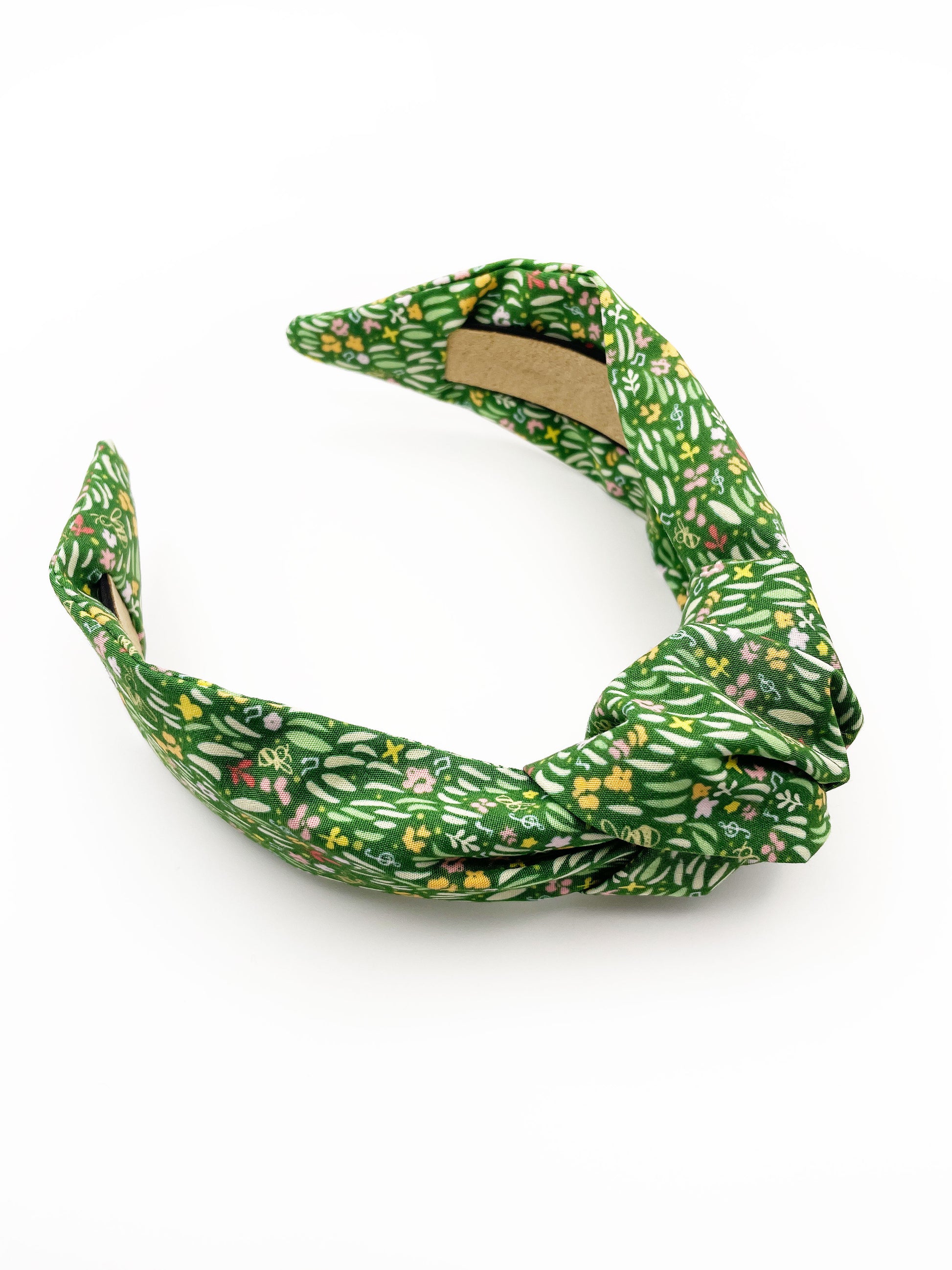 A handmade green floral knotted headband.