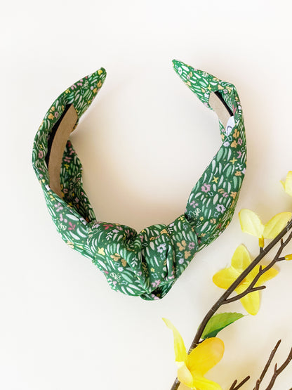 A handmade green floral knotted headband.