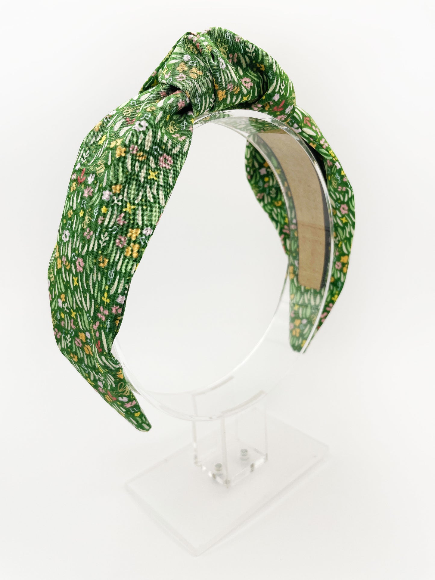 A handmade green floral knotted headband.