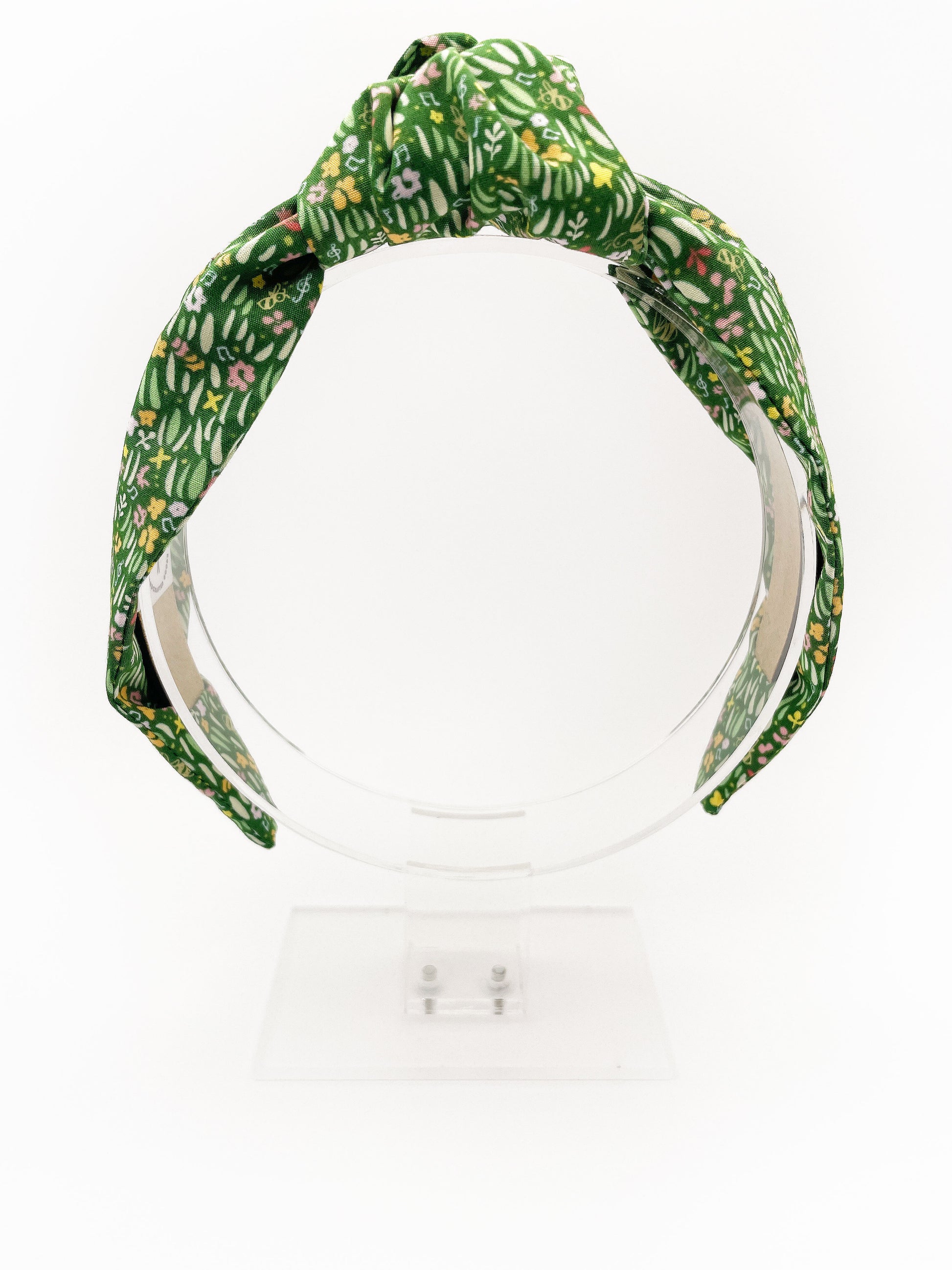 A handmade green floral knotted headband.