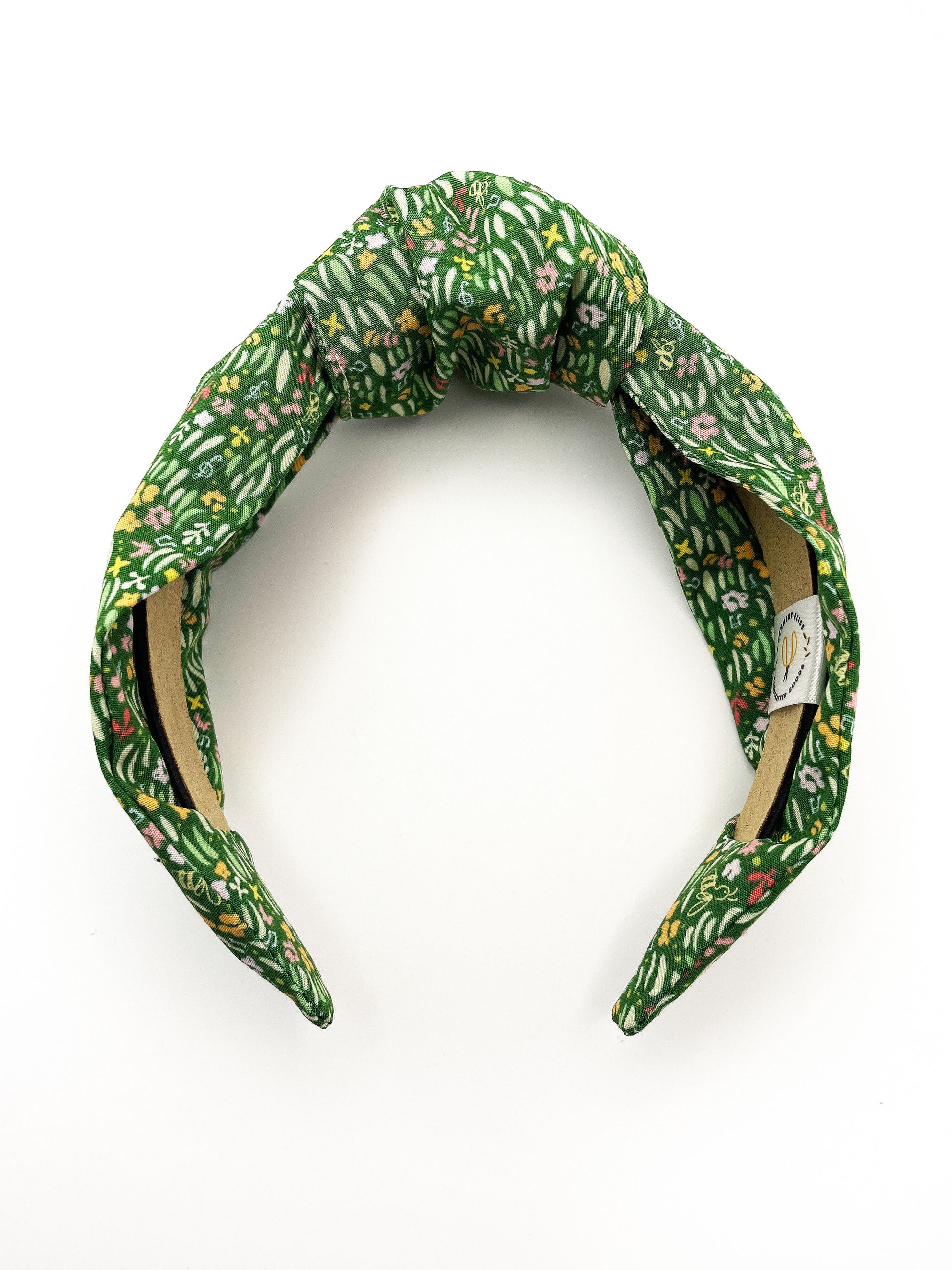 A handmade green floral knotted headband.