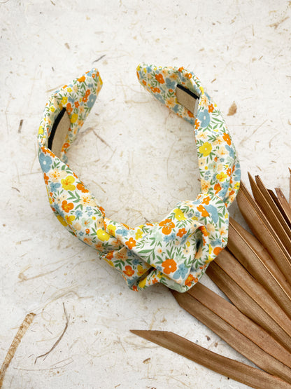 An off white knotted headband with a colorful ditsy floral print.