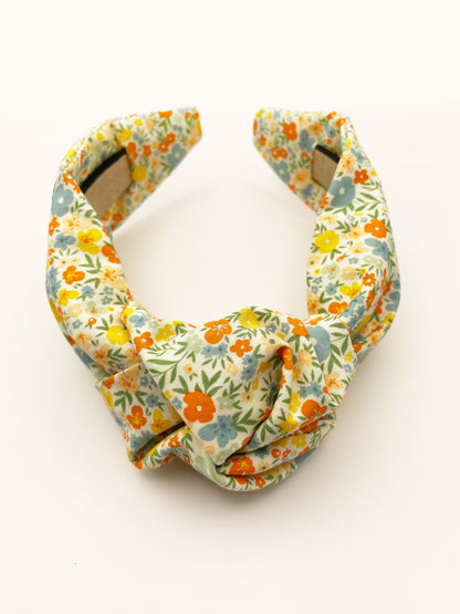 An off white knotted headband with a colorful ditsy floral print.