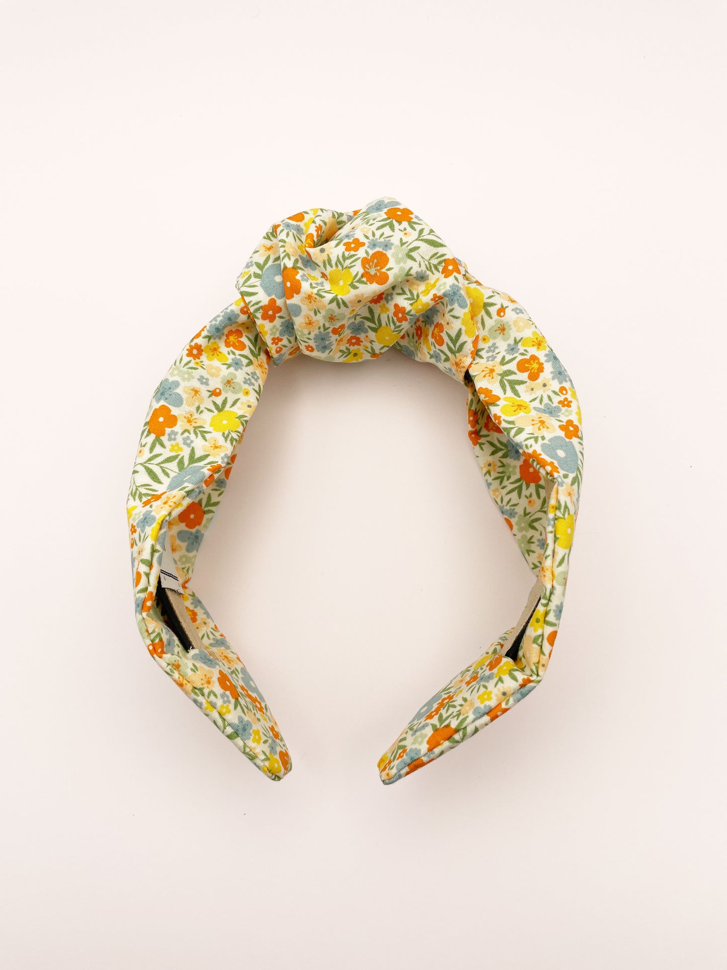 An off white knotted headband with a colorful ditsy floral print.