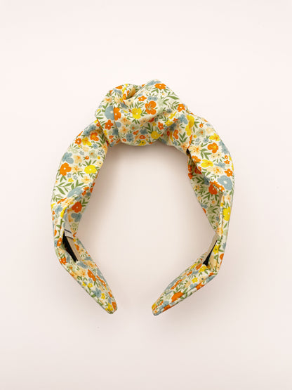 An off white knotted headband with a colorful ditsy floral print.