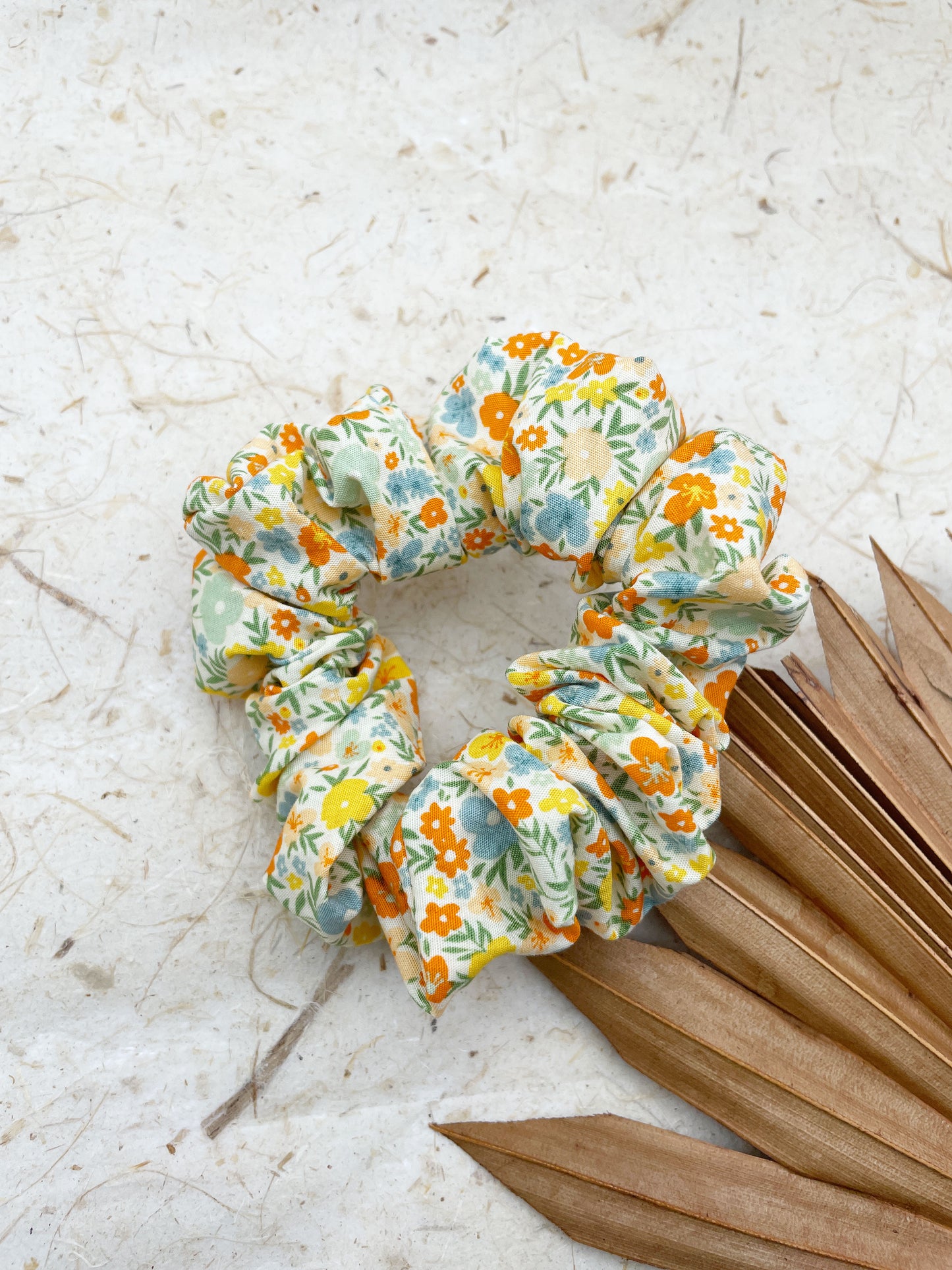 A neutral-toned scrunchie with a colorful ditsy floral print.