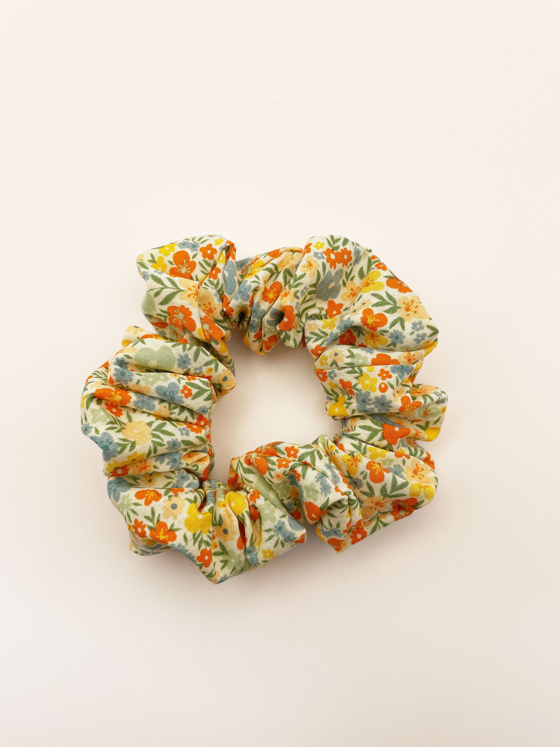 A neutral-toned scrunchie with a colorful ditsy floral print.