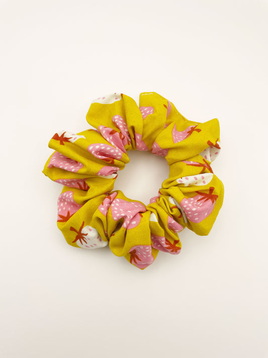 A yellow handmade scrunchie with an ivory and pink strawberry print.